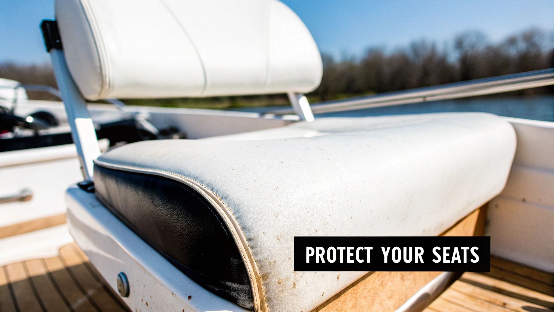 Close-up of a dirty white boat seat with black trim, showing mildew spots, under a blue sky.