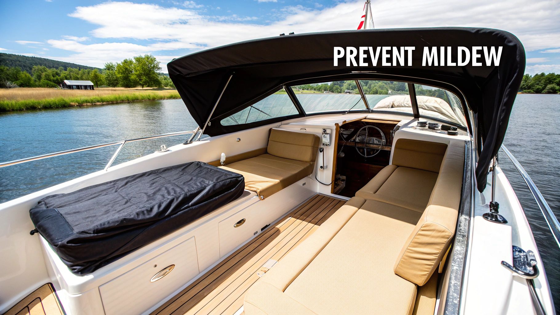 A boat interior with tan cushions, a black canopy, and 'PREVENT MILDEW' text, on a sunny day.