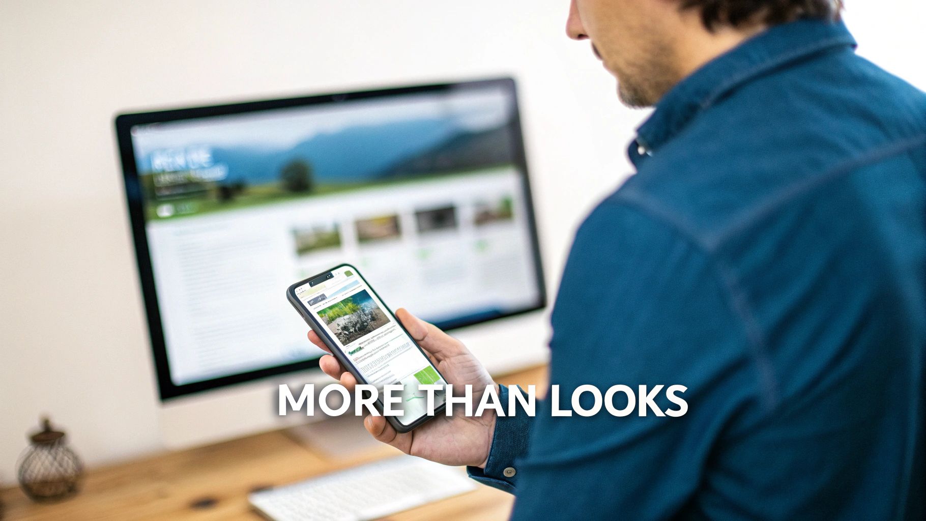 A person views a website on a smartphone and desktop monitor, highlighting responsive design.