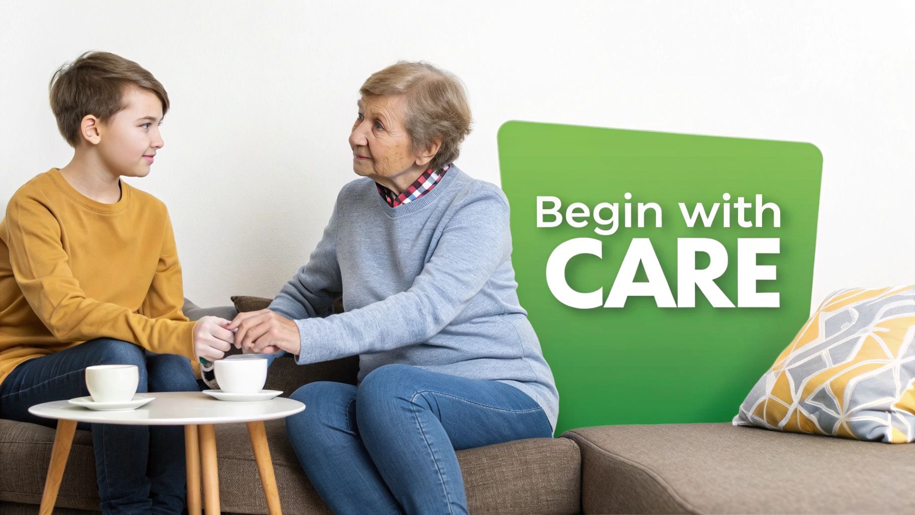 A young boy holds an elderly woman's hand on a couch, with a 'Begin with CARE' sign.