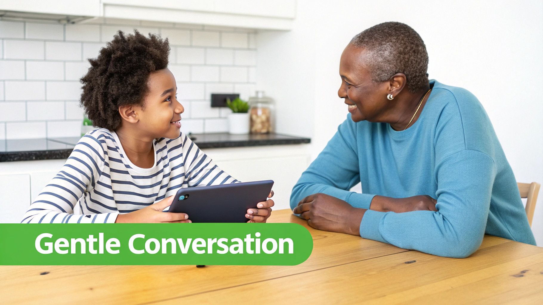 A happy Black grandmother and grandson share a gentle conversation while looking at a tablet.
