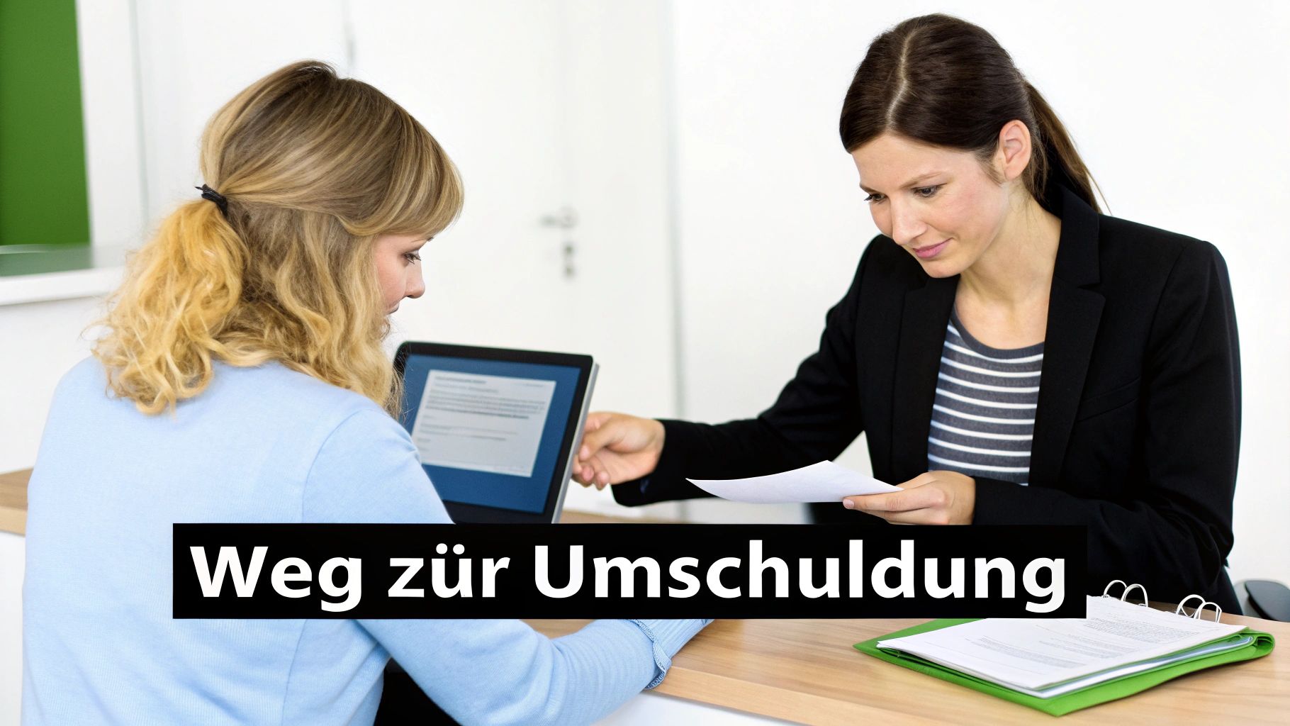 Zwei Frauen besprechen am Schreibtisch Unterlagen und einen Laptop zum Thema Umschuldung.