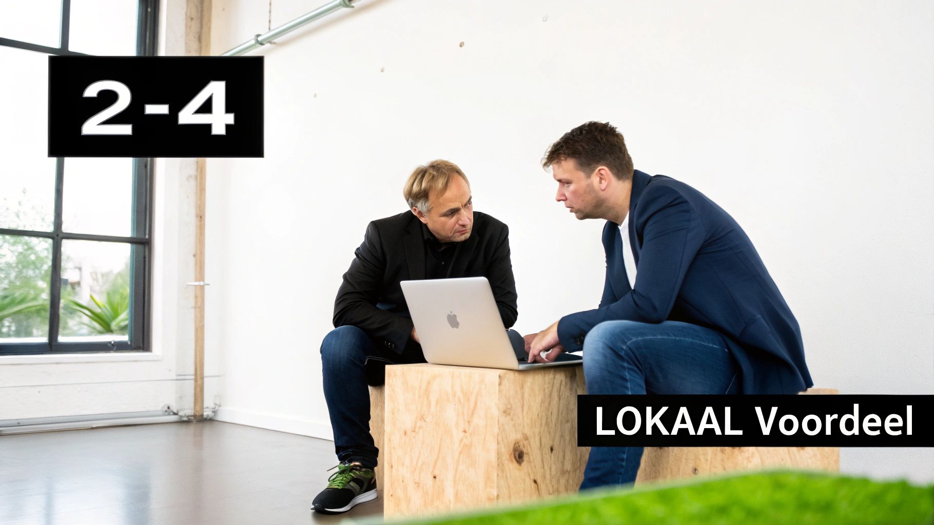 Twee mannen bespreken inhoud op een laptop, zittend in een moderne kantoorruimte.