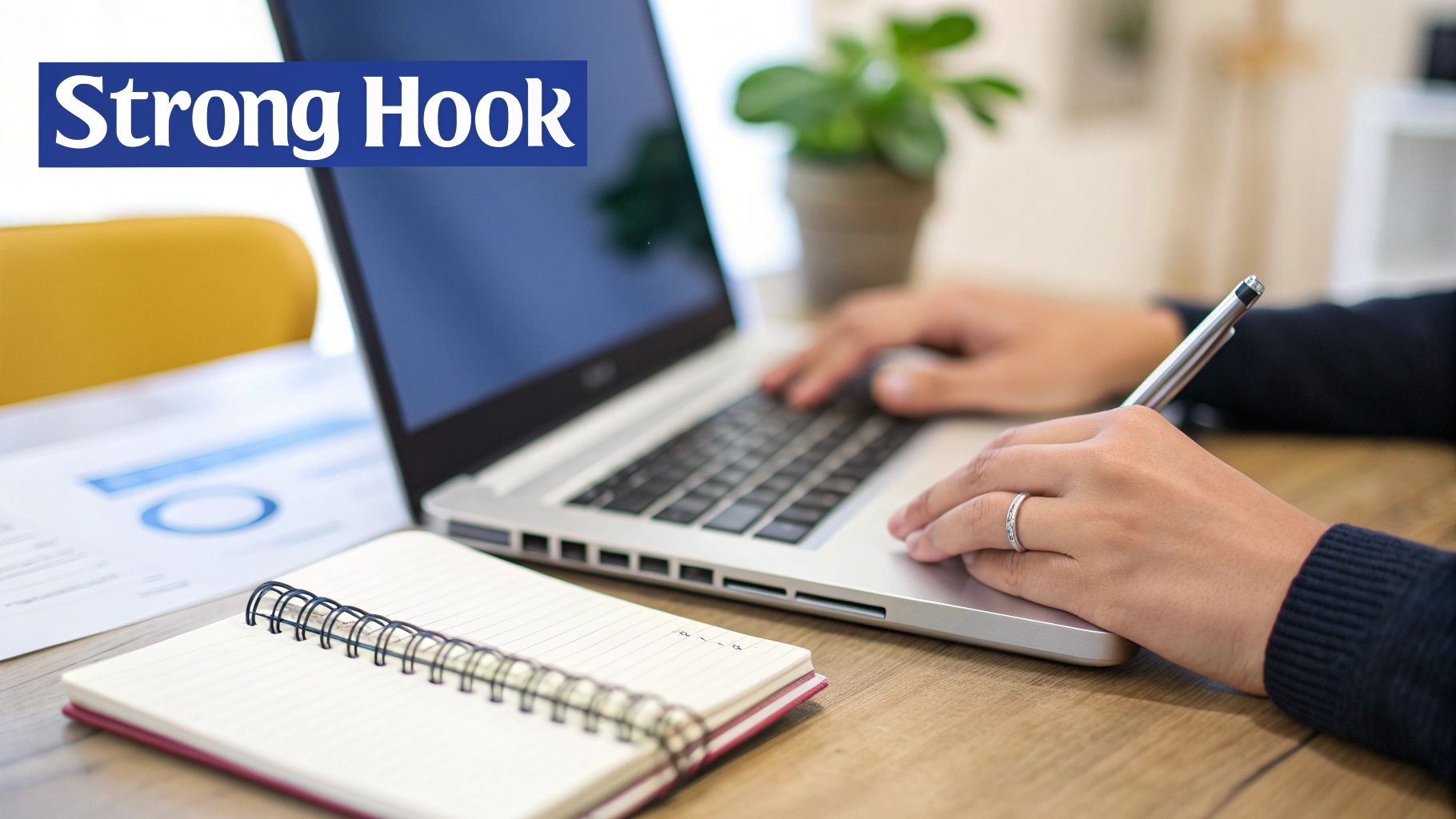 A person working on a laptop at a desk with an open notebook, pen, and a 'Strong Hook' banner.