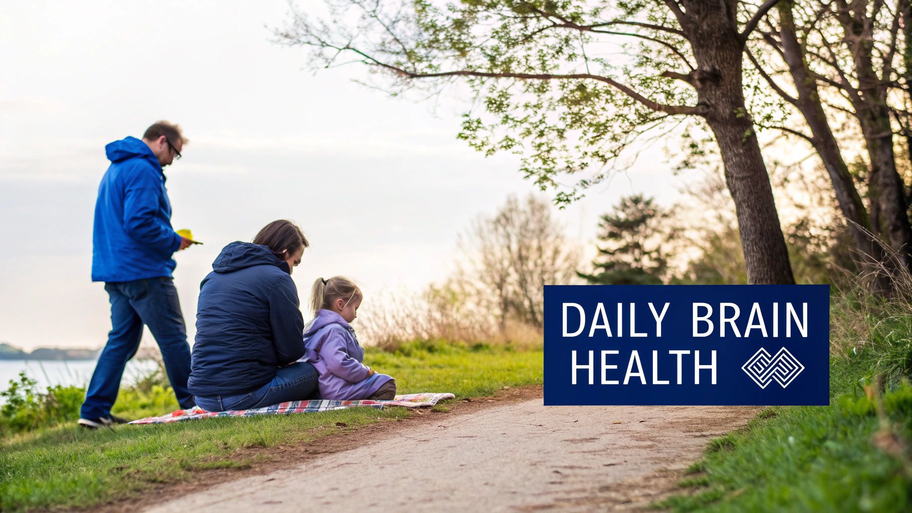 A family on a blanket by a path near a lake, with a "DAILY BRAIN HEALTH" banner.