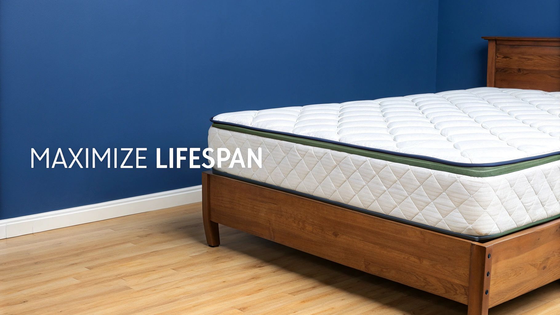 A clean white mattress with green and blue trim rests on a wooden bed frame in a room with a blue wall.