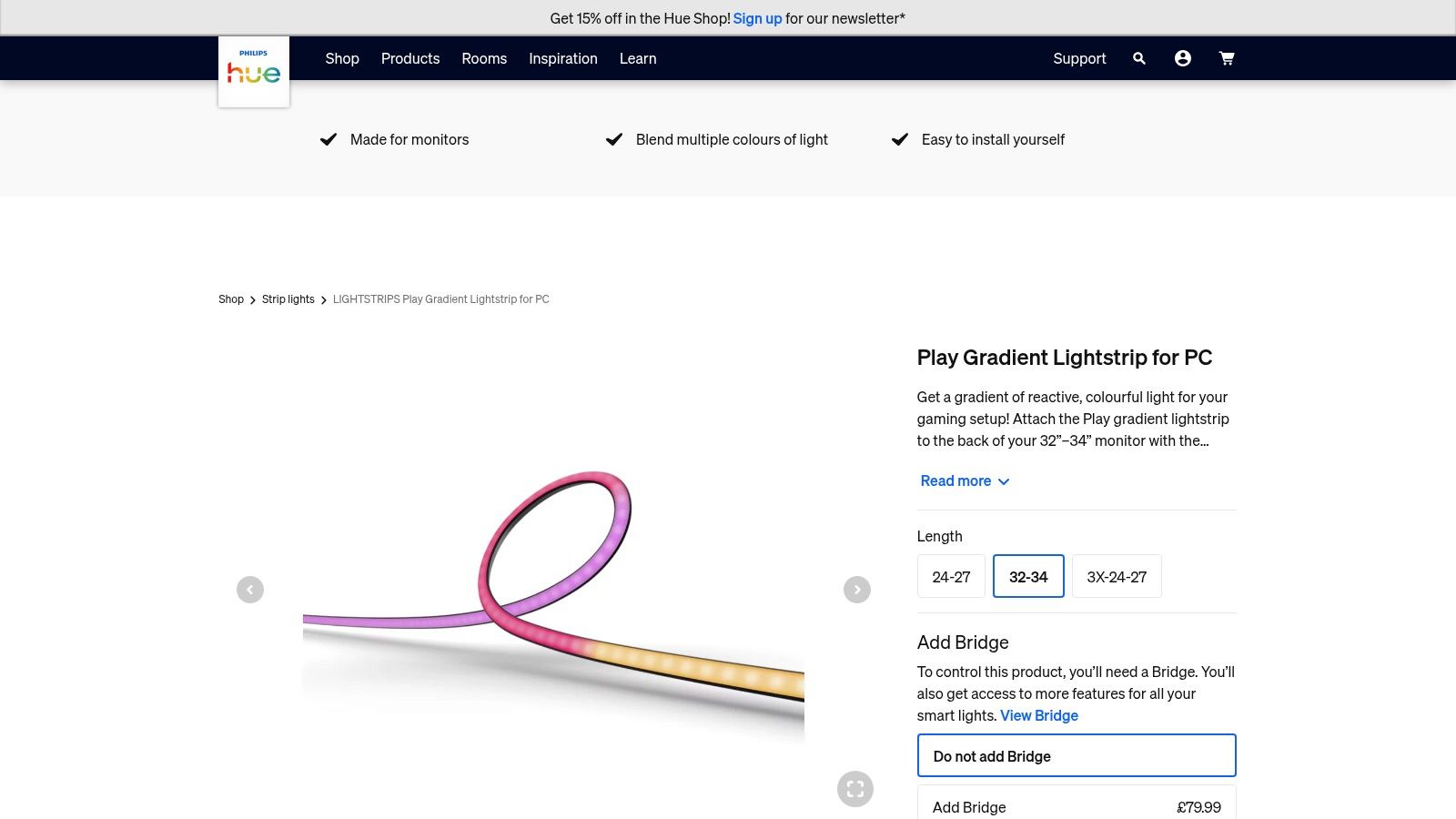 A Philips Hue Play Gradient Lightstrip attached to the back of a PC monitor, casting a multi-coloured glow against the wall that matches the on-screen image.