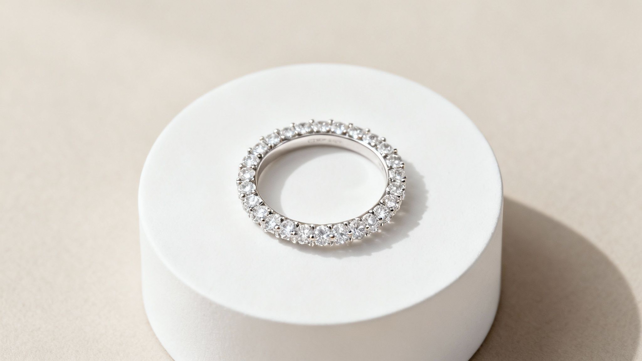 An eternity band with diamonds all around the ring, sitting on a jewellery display.