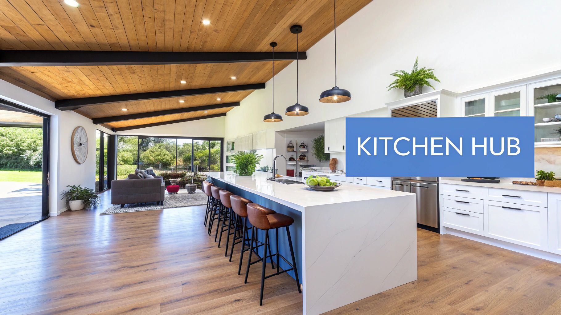 A picture of a open floor plan with a large kitchen island with white quartz countertops and waterfall, brown wood floors and white cabinets with words on the image that say kitchen hub.