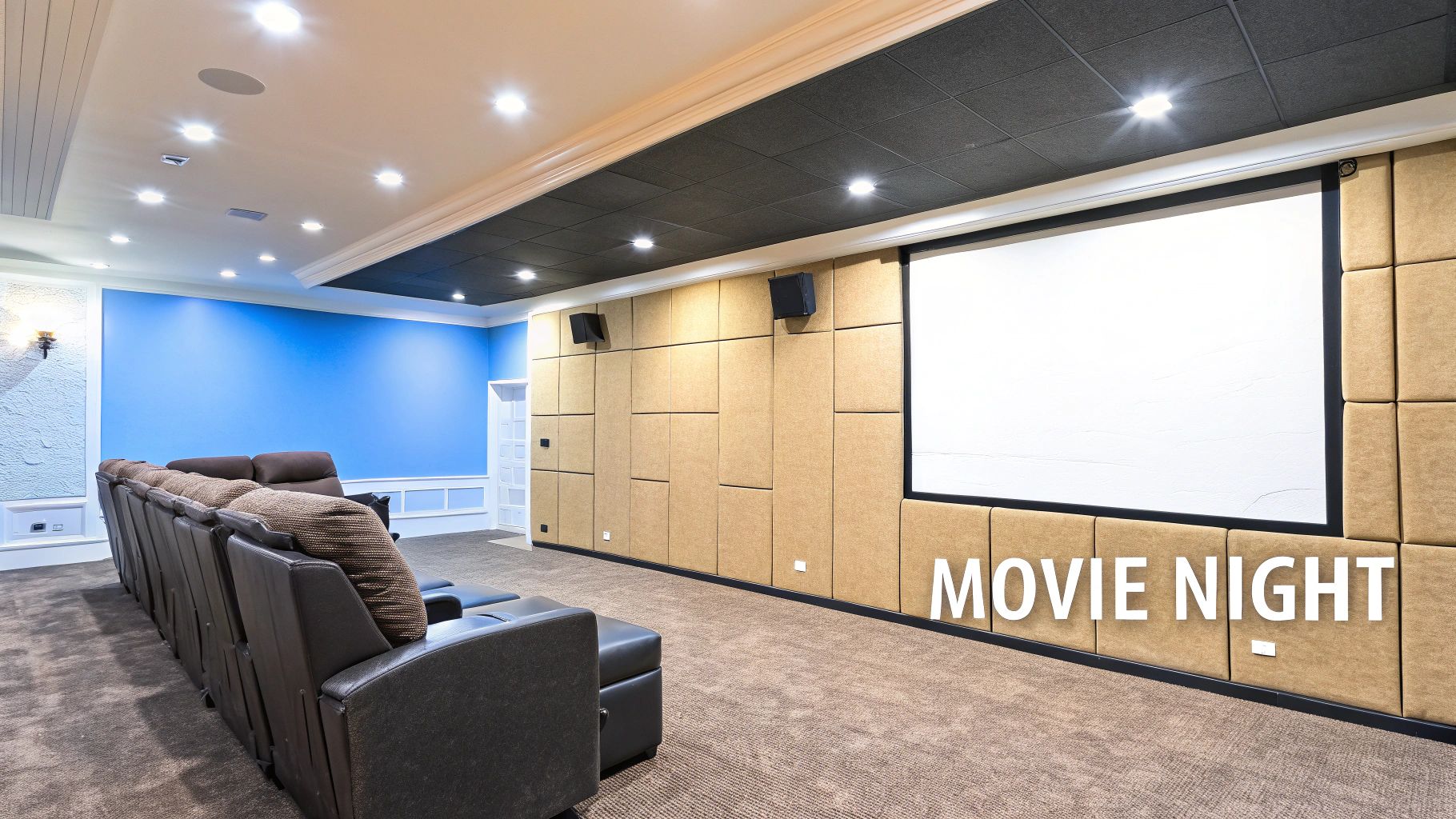 A home basement theater with a larch couch in front of a large screen on the wall.