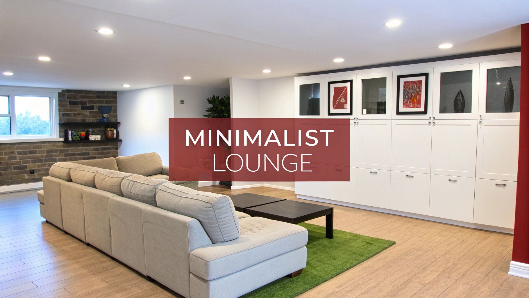 A modern basement lounge featuring a grey sectional sofa, black coffee tables, and white built-in cabinets.