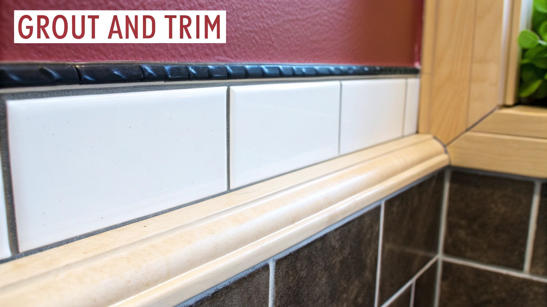 Close-up of white subway tiles with dark grout lines, a black border, and light wood trim.