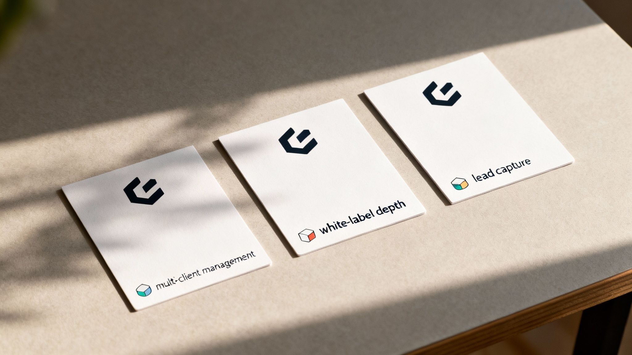 Three white cards on a brown surface, displaying business concepts with a logo and cube icons.