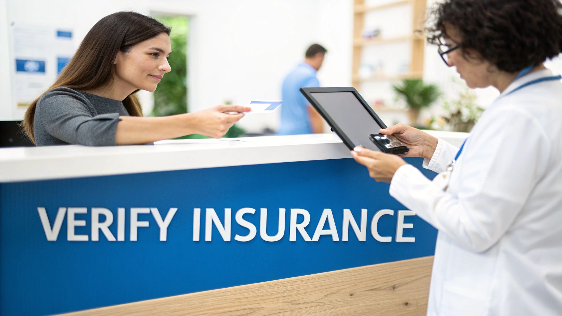 Patient provides insurance card to a healthcare worker at a reception desk for verification.