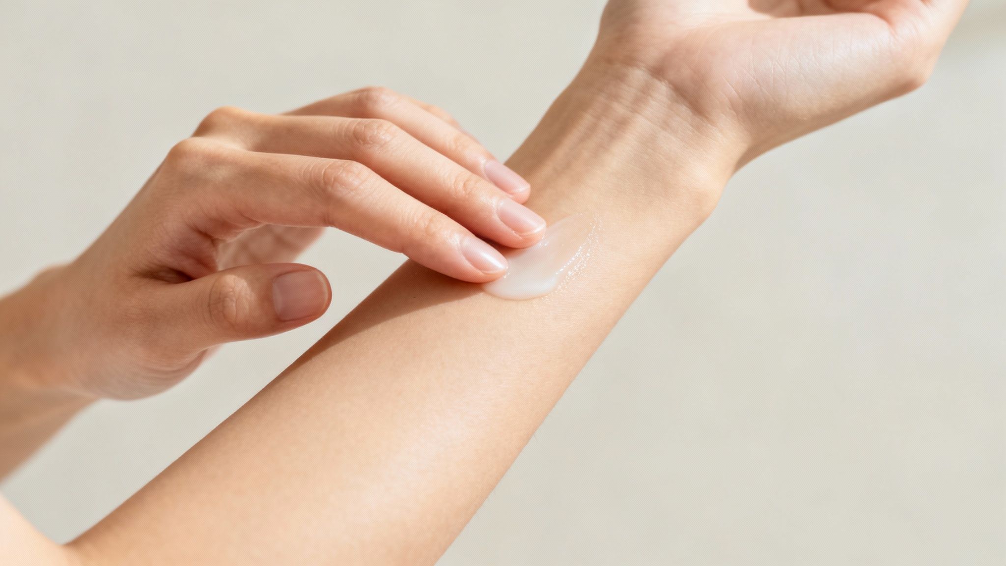 Person applying moisturizer or lotion on forearm to hydrate skin before perfume application
