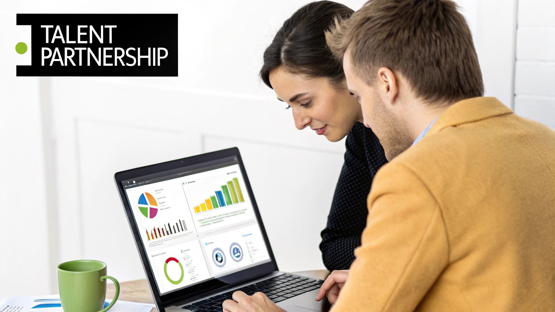 Two professionals collaborate, reviewing data and charts on a laptop screen, symbolizing talent partnership.