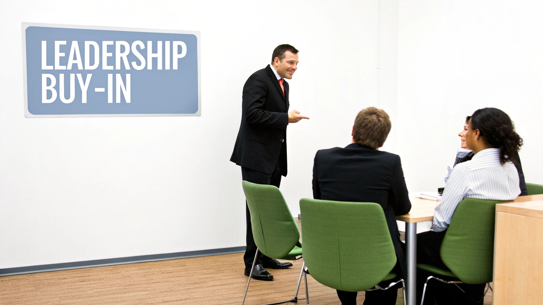 A business professional presents to three colleagues seated at a table, under a "LEADERSHIP BUY-IN" sign.