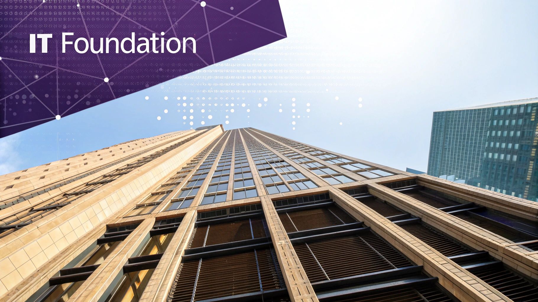 Upward view of a tall modern building with 'IT Foundation' text and a digital network overlay.