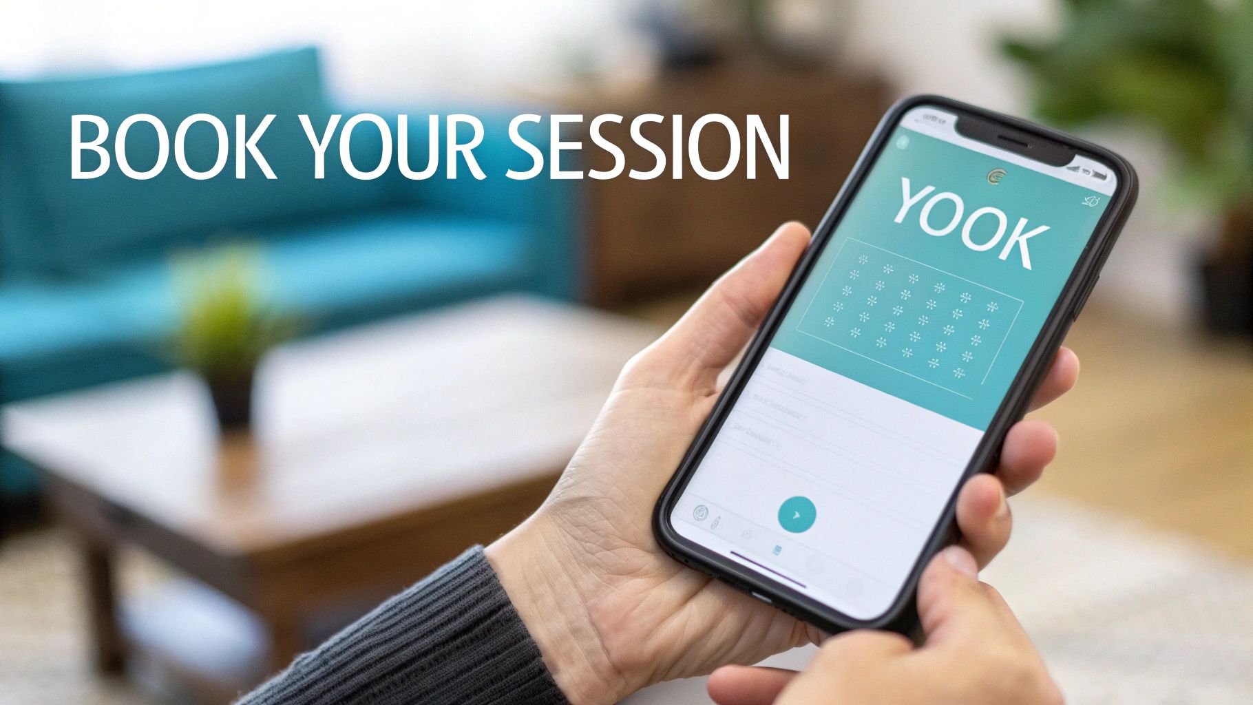 A close-up of hands holding a smartphone displaying a &#39;YOOK&#39; app for booking sessions.