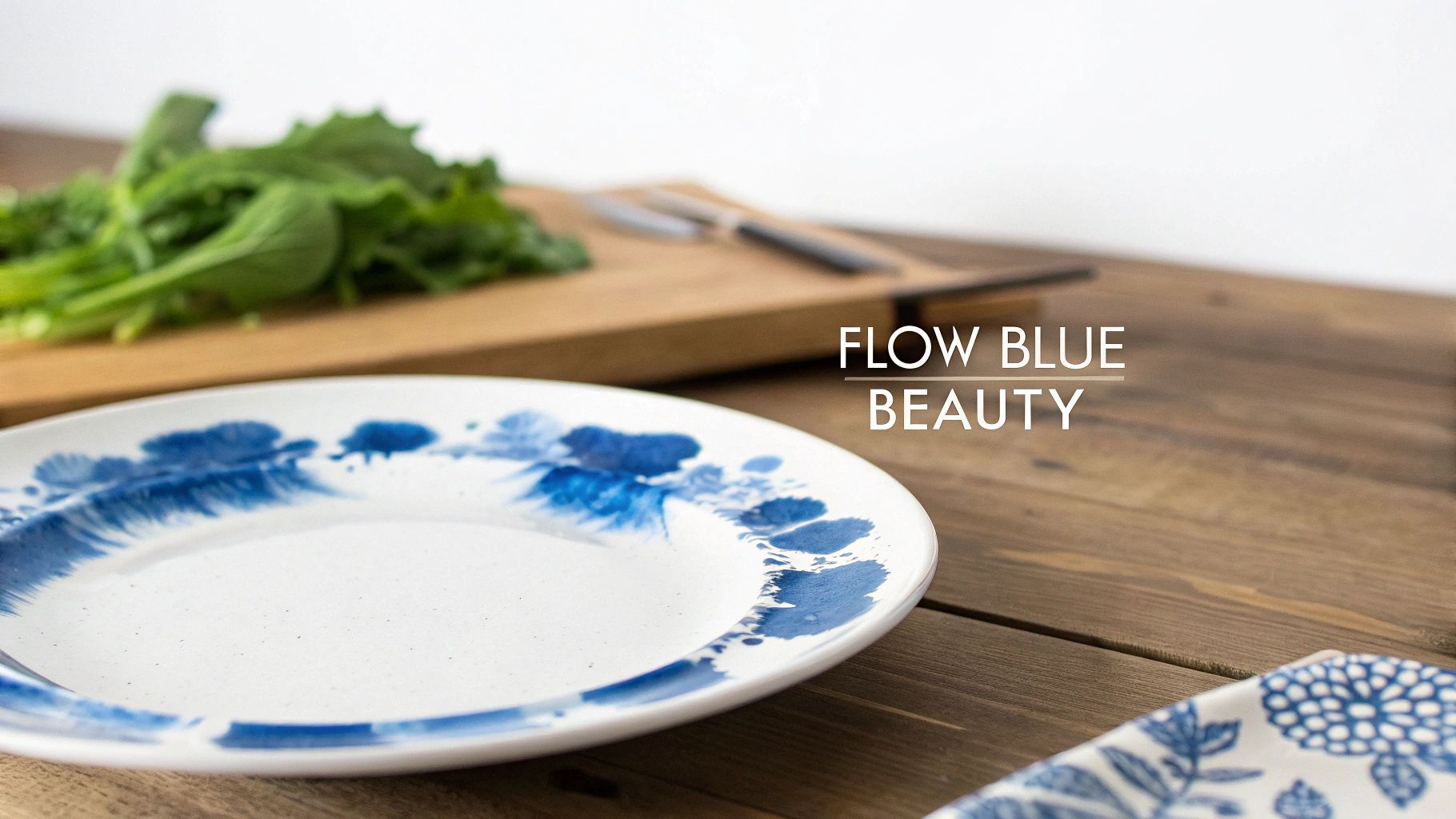 Flow blue patterned ceramic plate on wooden table with cutting board and fresh greens