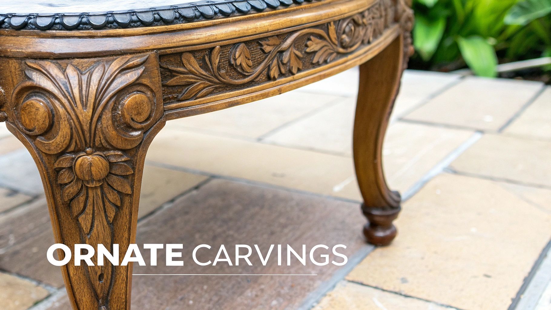 A close-up of an ornate, hand-carved floral motif on a piece of Victorian mahogany furniture.