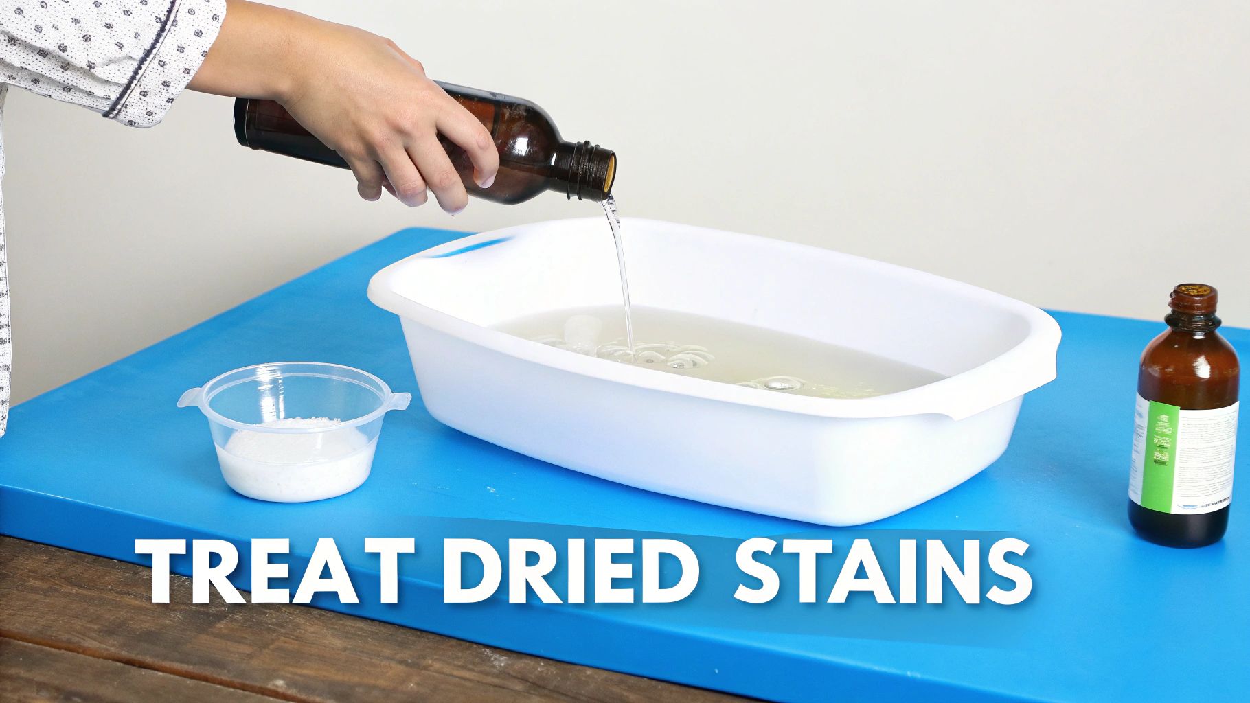 A hand pours liquid from a brown bottle into a white basin, preparing a solution for stain removal.