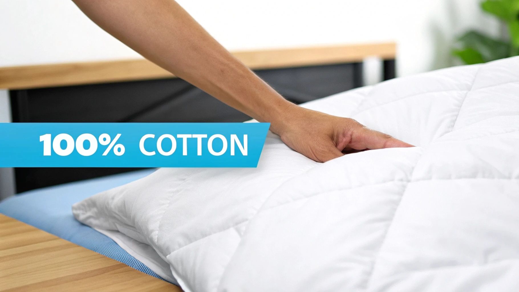 A person's hand gently presses on a white, soft, quilted comforter, emphasizing the '100% COTTON' label.