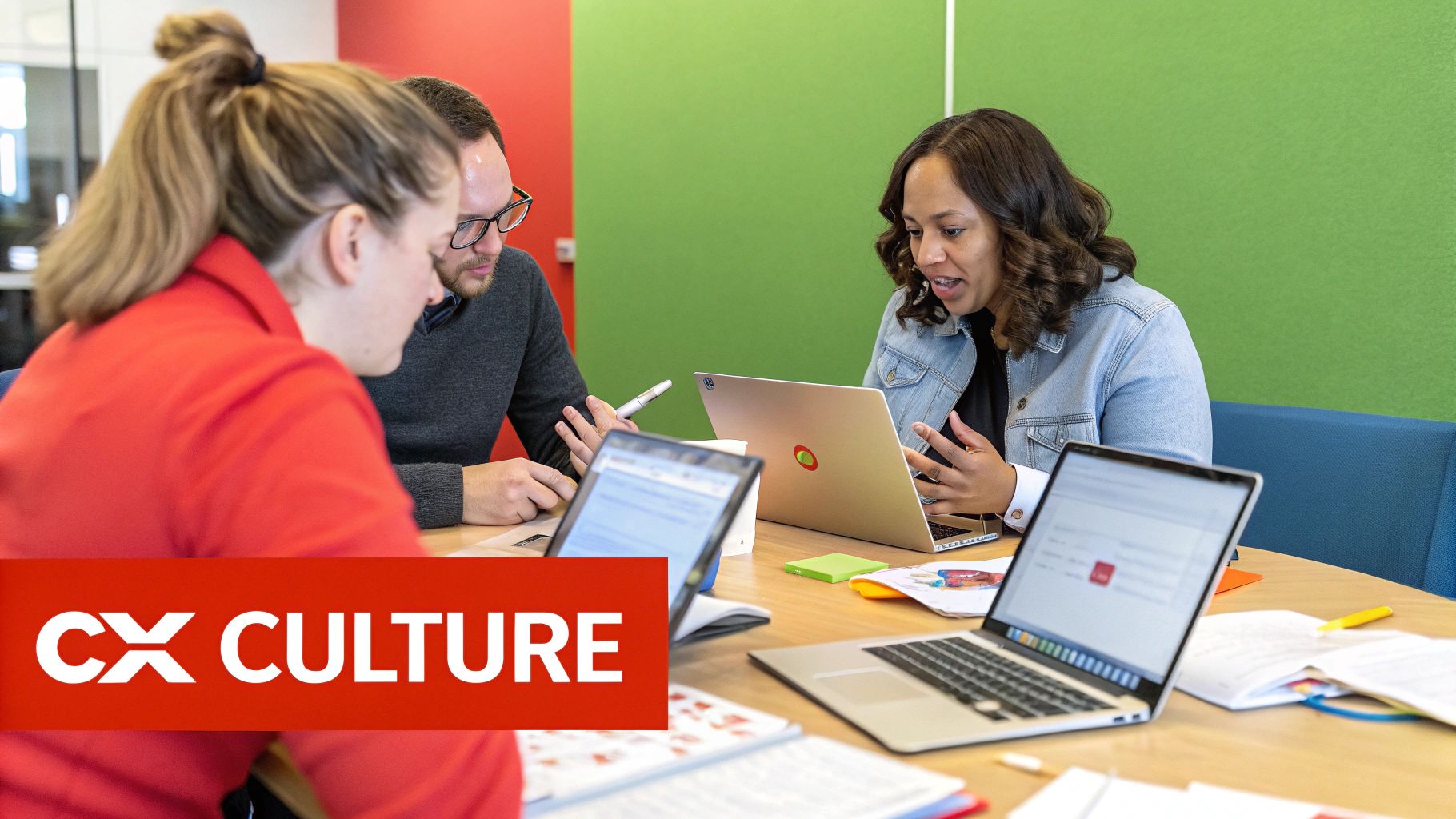 A diverse team collaborates in a modern office, pointing at a large screen displaying customer experience dashboards and smiling.