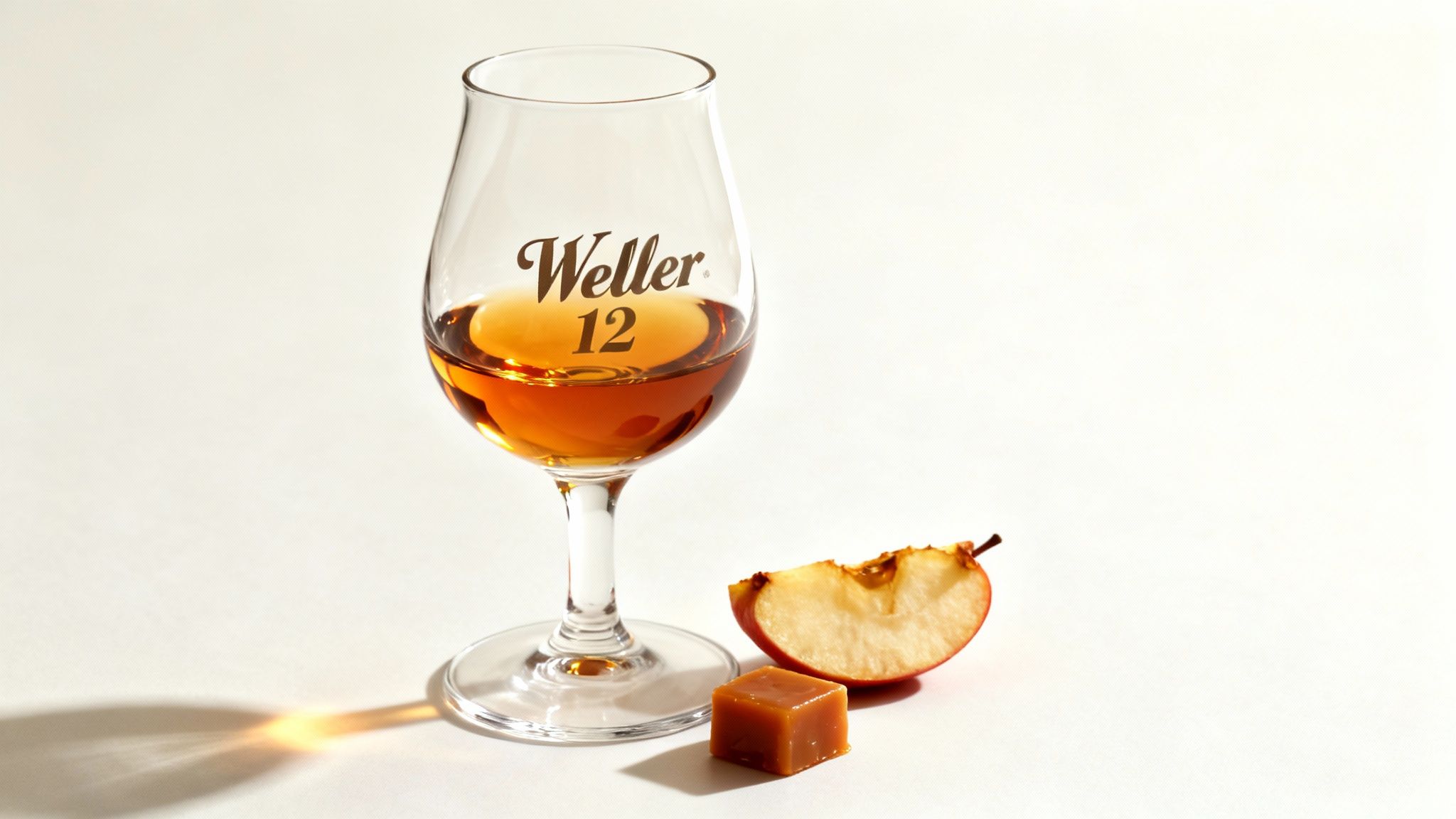 A bottle of Weller
12 bourbon resting on a wooden surface, with a glass of bourbon nearby