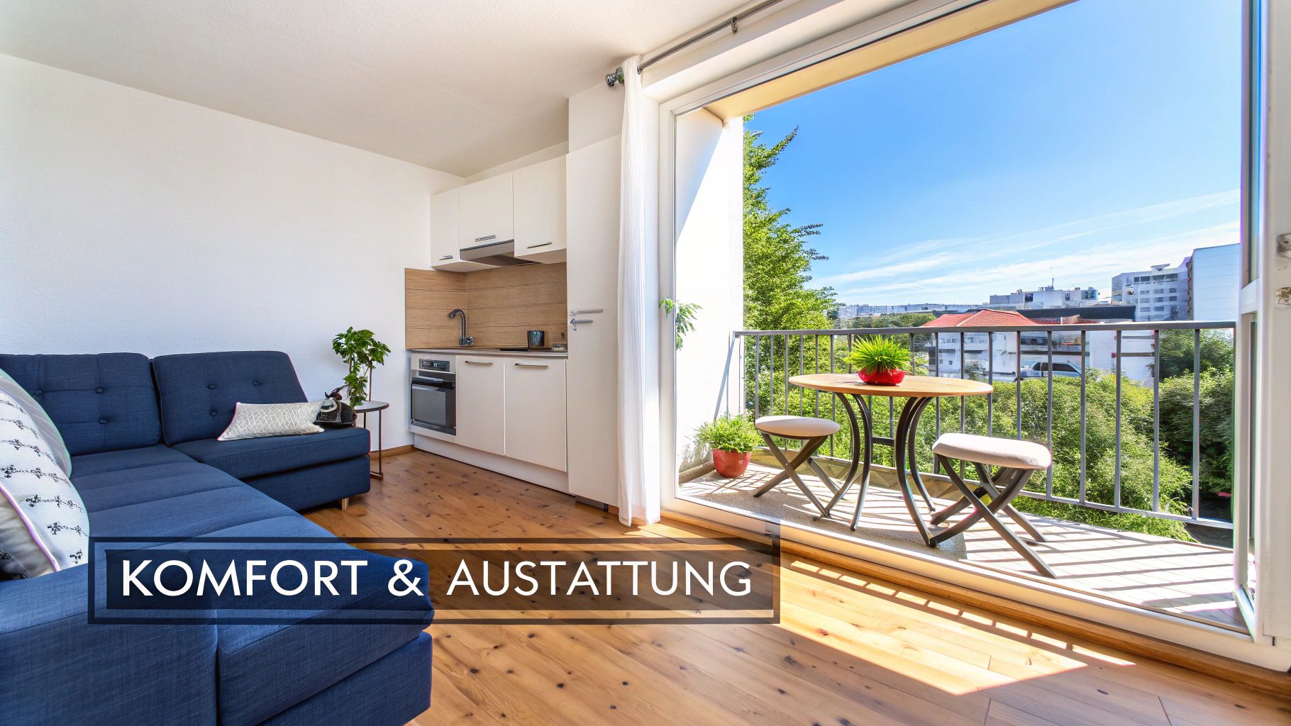 Heller Wohnbereich mit blauer Couch, moderner Küche und offener Balkontür mit Stadtblick und Sitzgelegenheiten.