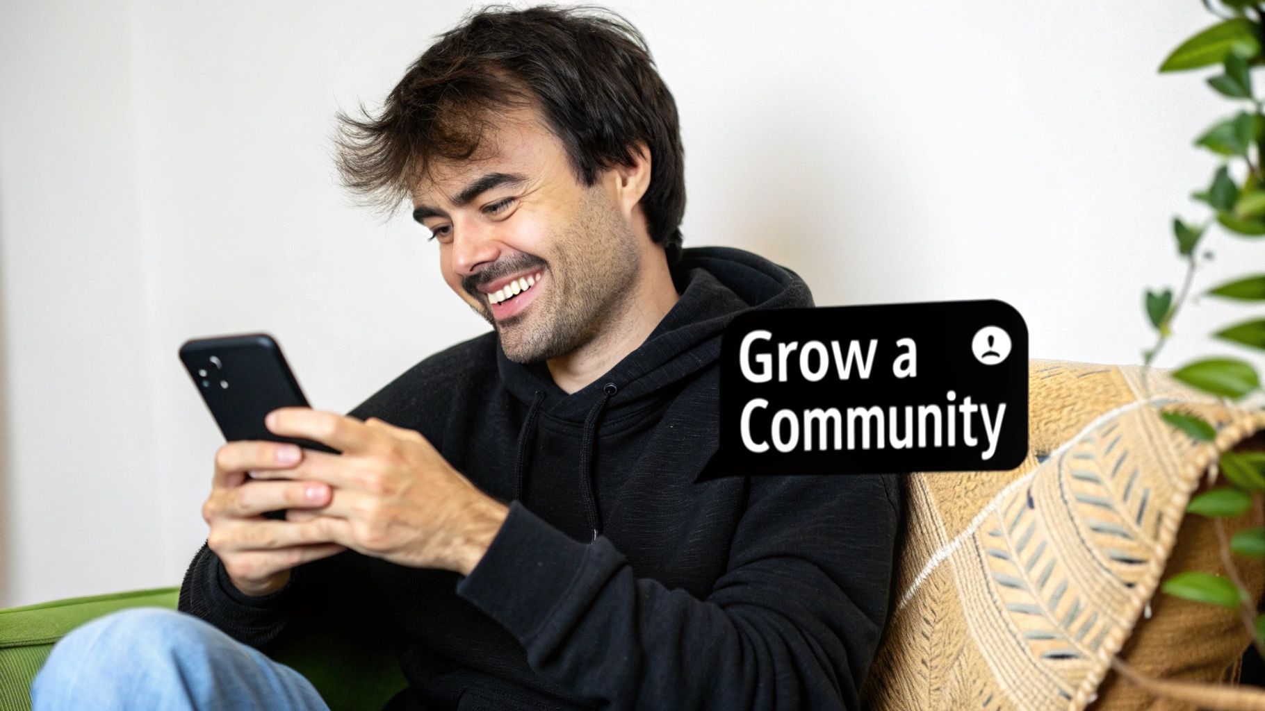 A smiling man in a black hoodie looks at his phone. A speech bubble says 'Grow a Community'.
