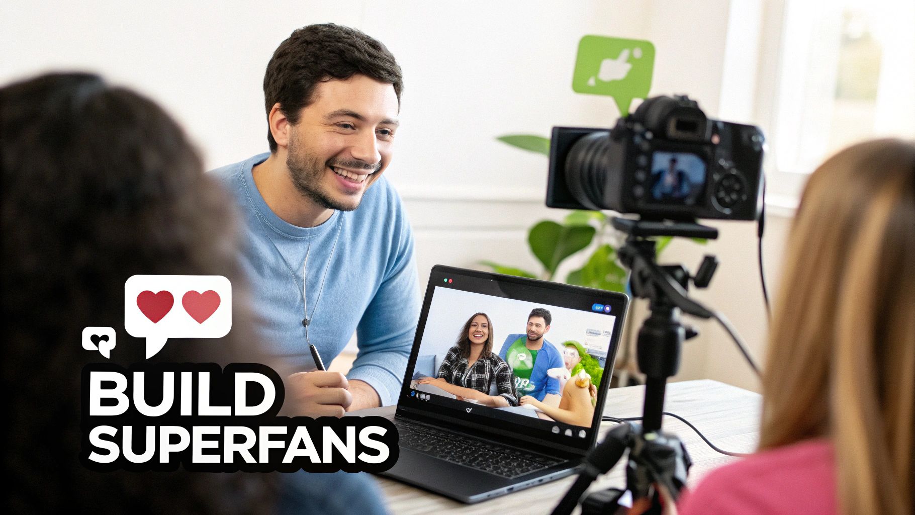 Smiling man watching a video call on a laptop, with a camera recording, suggesting online content creation to build superfans.
