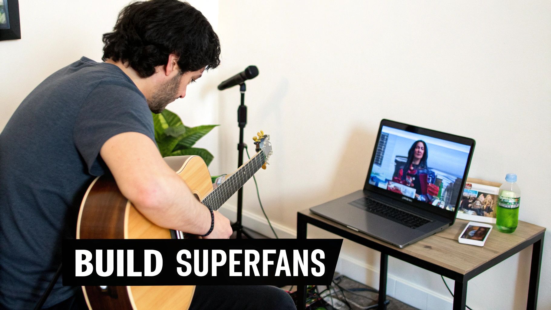 A man plays an acoustic guitar, looking at a laptop screen showing a woman, with a microphone and text "BUILD SUPERFANS".