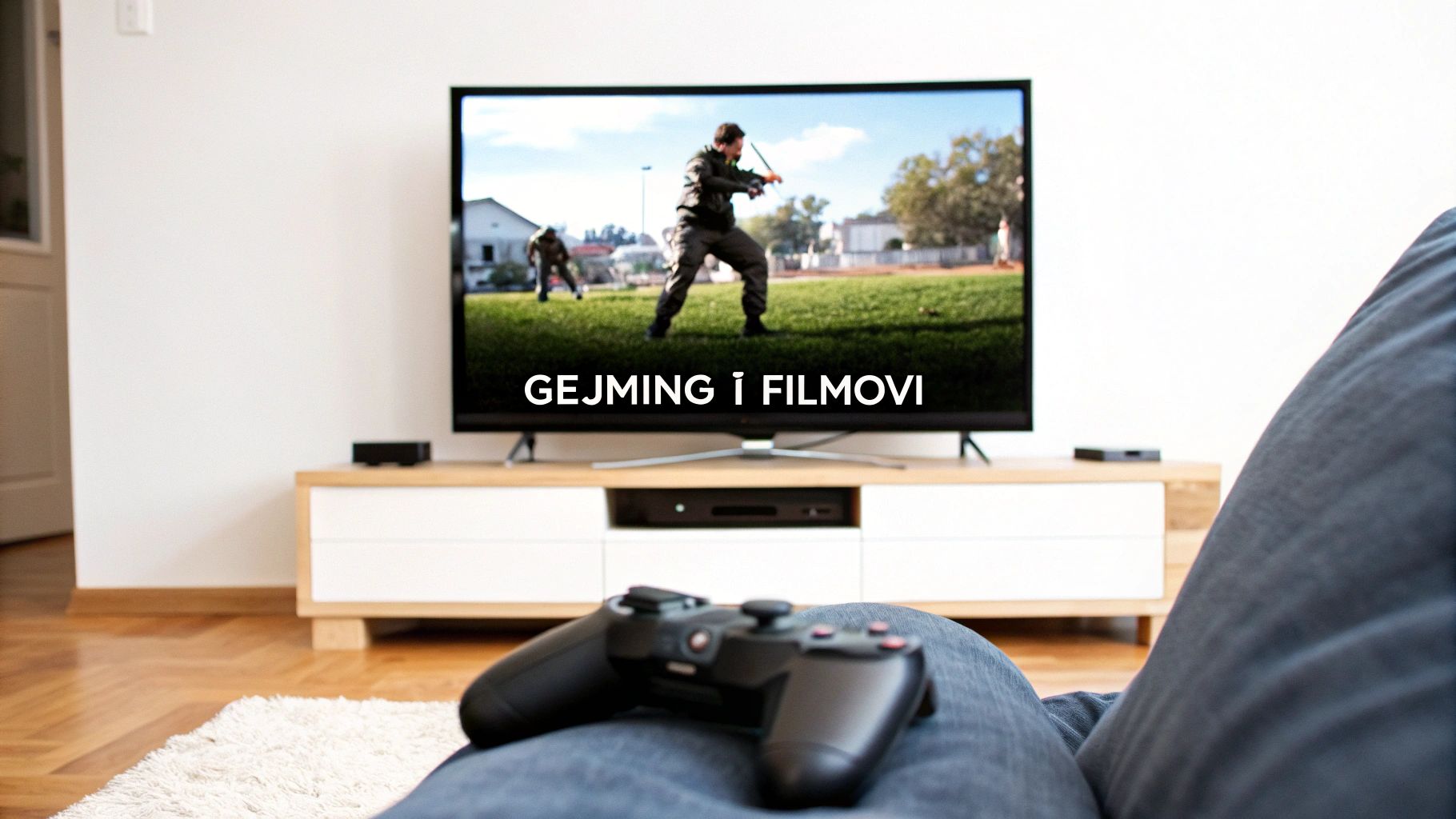 Osoba sedi na kauču sa džojstikom u krilu, gledajući televizor sa natpisom „GEJMING I FILMOVI“.