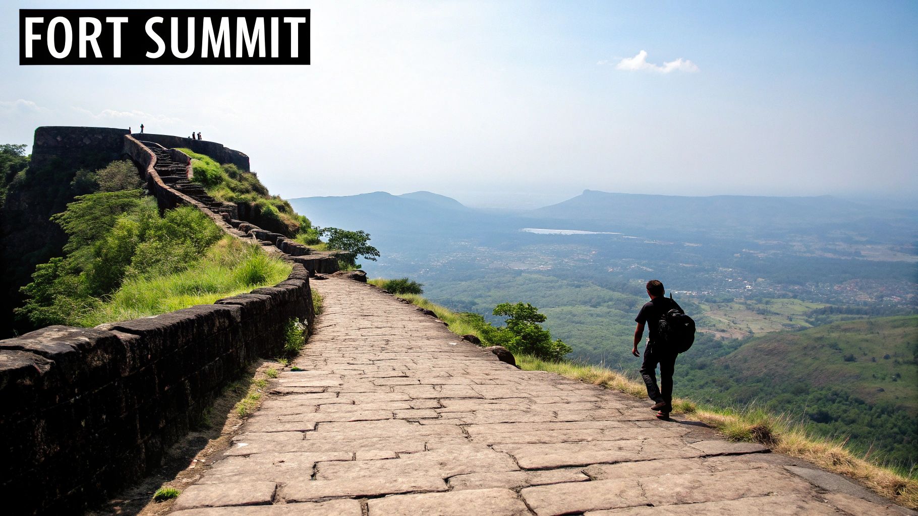 10 Amazing Places Near Pune for Two Day Trip in 2025 3 Hiker walking on stone pathway at Fort Summit overlooking scenic valley landscape near Pune