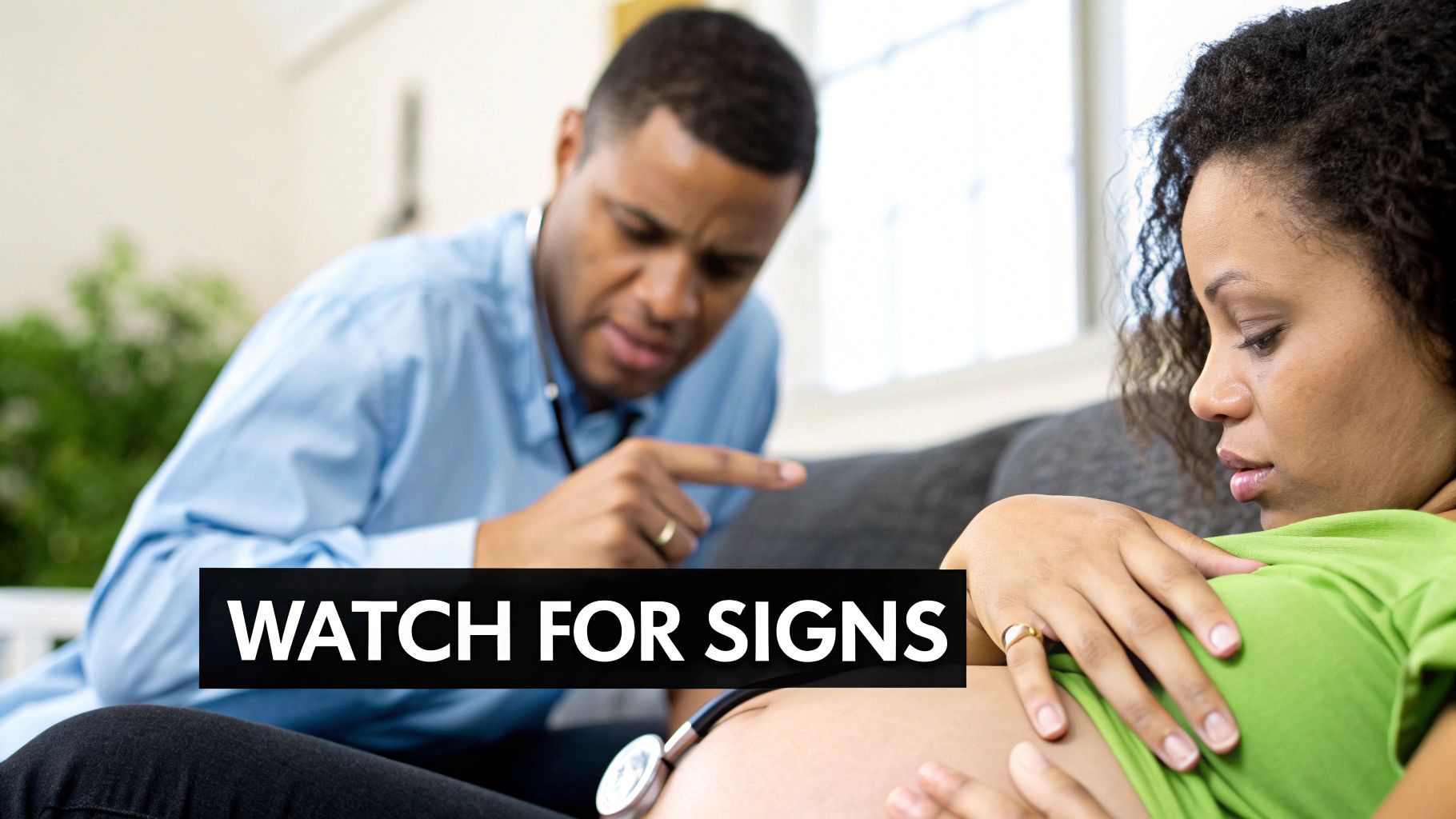 An African American doctor talks to a pregnant woman, emphasizing signs to watch for.