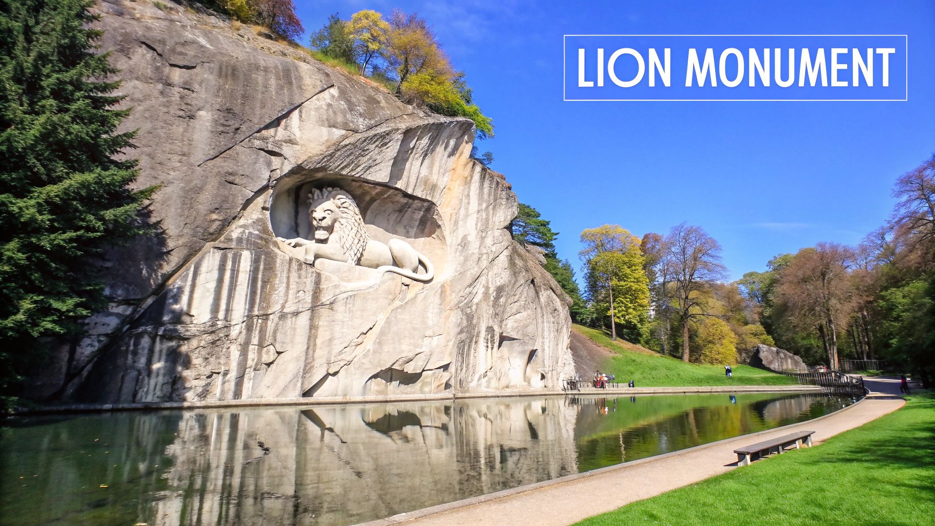 The famous Lion Monument in Lucerne, Switzerland, carved into a rock face, reflecting in a serene pond.