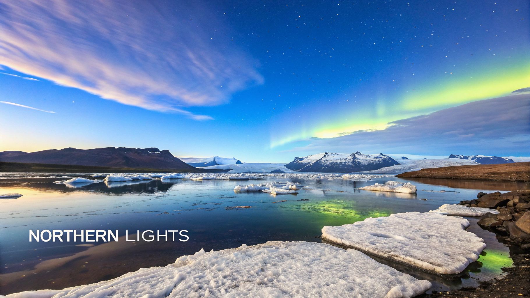 Stunning Northern Lights illuminate a glacial lagoon with icebergs and snow-capped mountains under a starry sky.