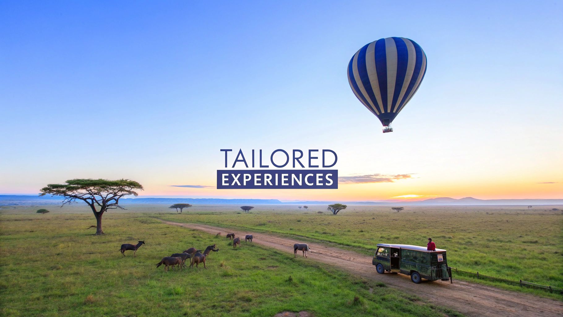 A hot air balloon floats over an African savanna at sunrise with wildebeest and a safari jeep.
