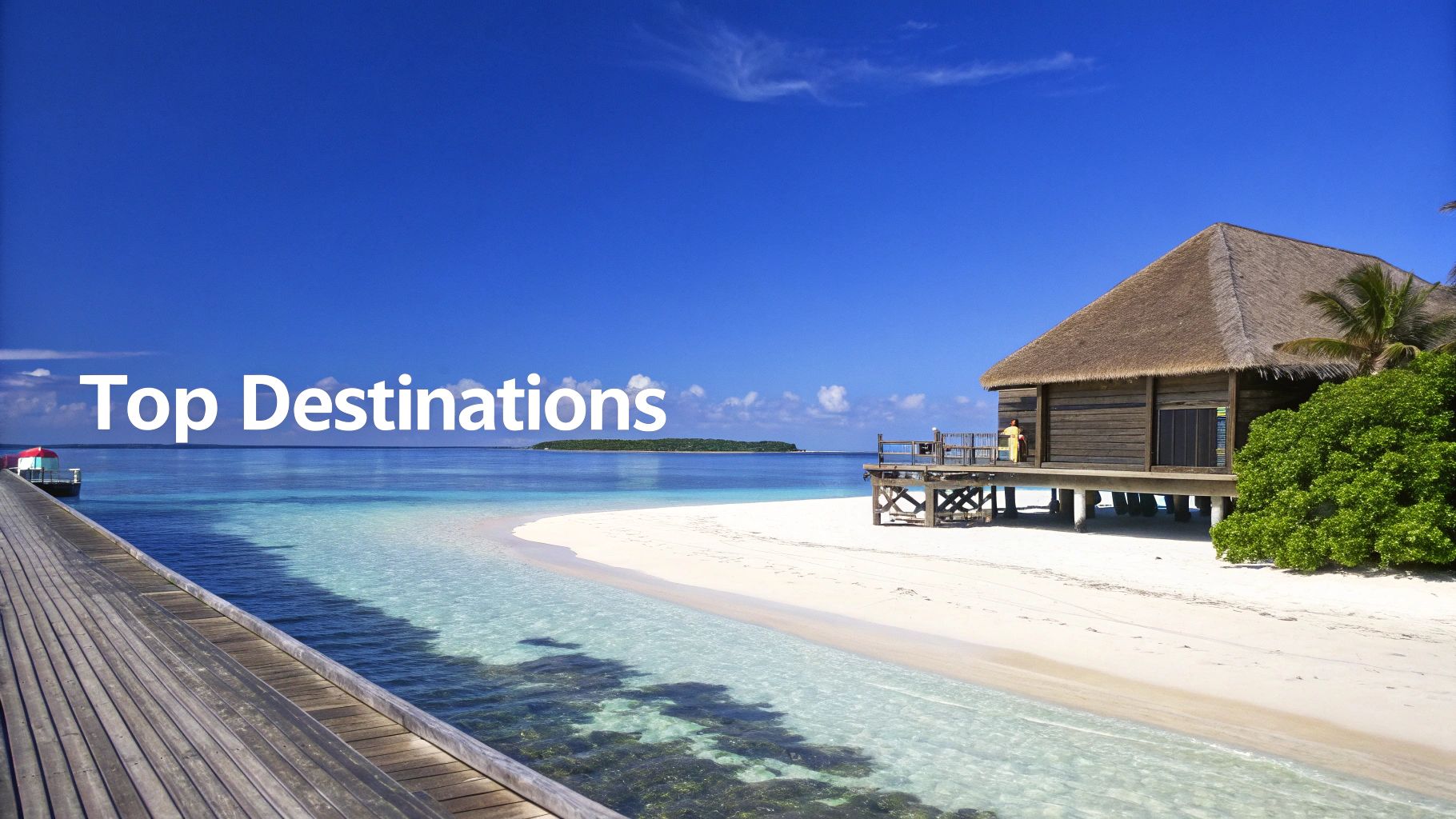 Two beach chairs and an umbrella on a pristine white sand beach overlooking turquoise water.