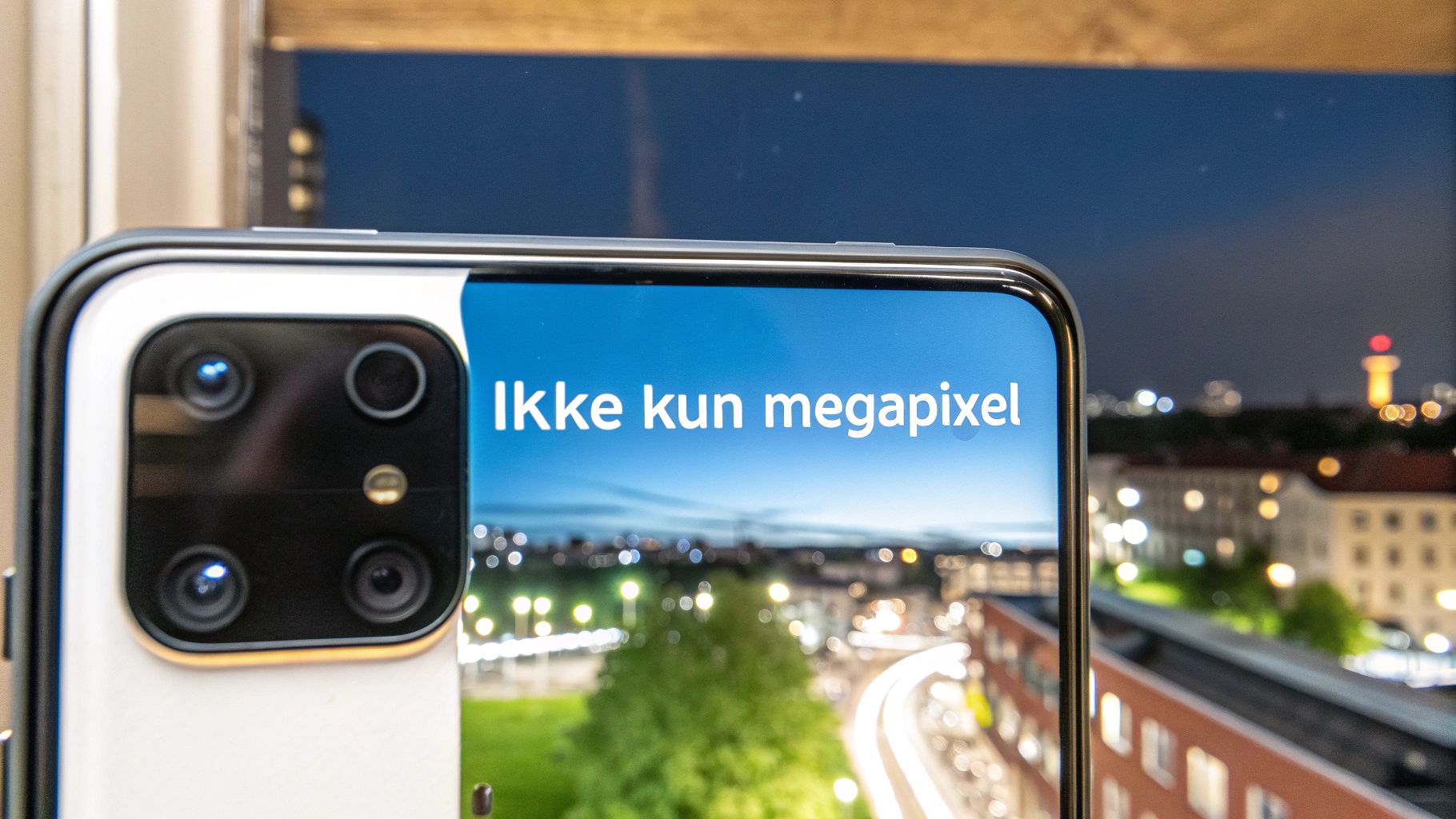 En person holder en smartphone og tager et billede af et smukt landskab, hvor kameraets linse er i fokus.