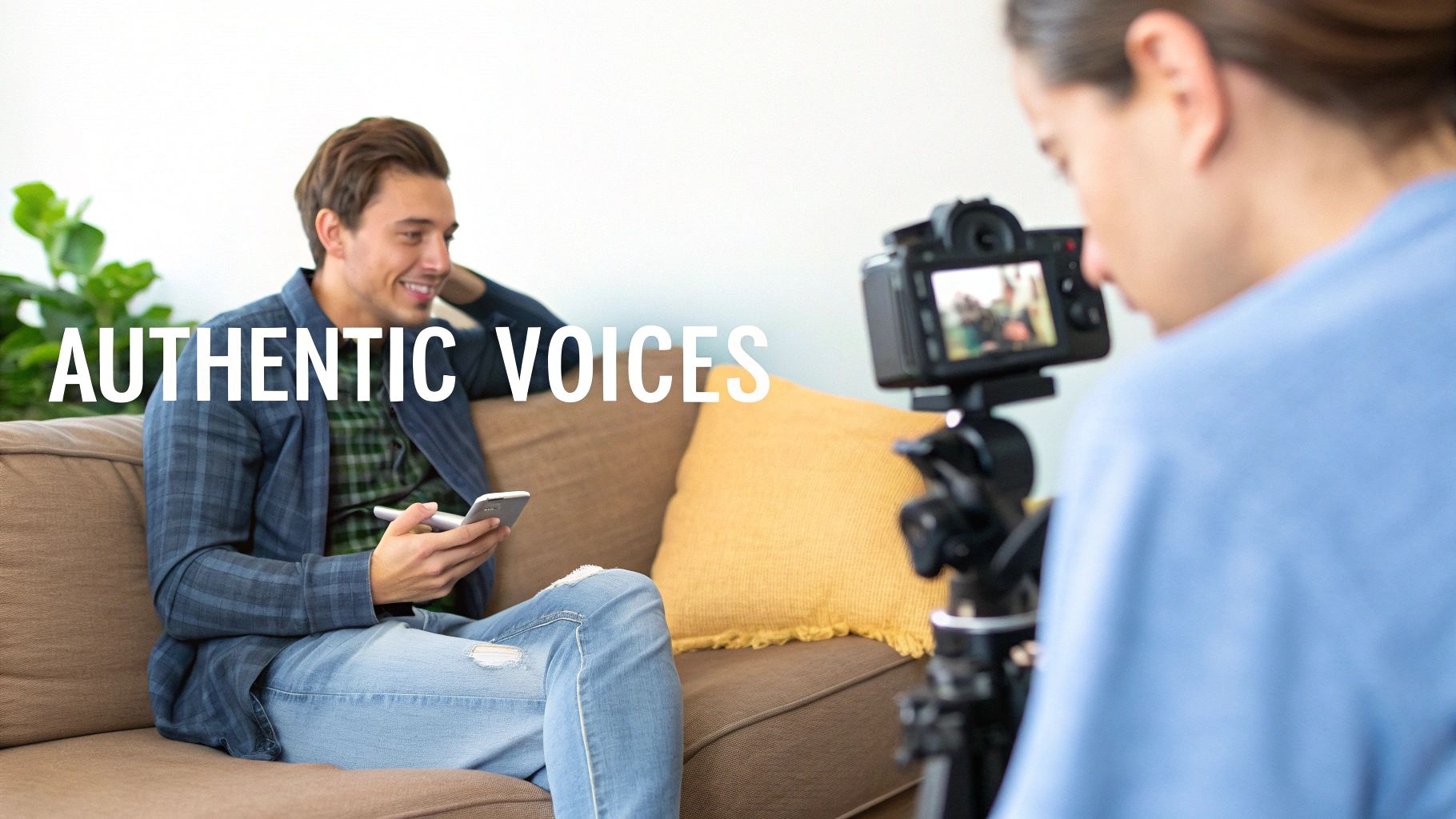 An overhead shot of a person creating content with a smartphone, camera, and laptop on a wooden desk.