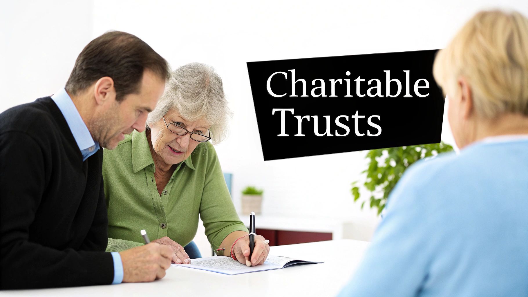 Two adults review and sign documents, likely for charitable trusts, in an office setting.