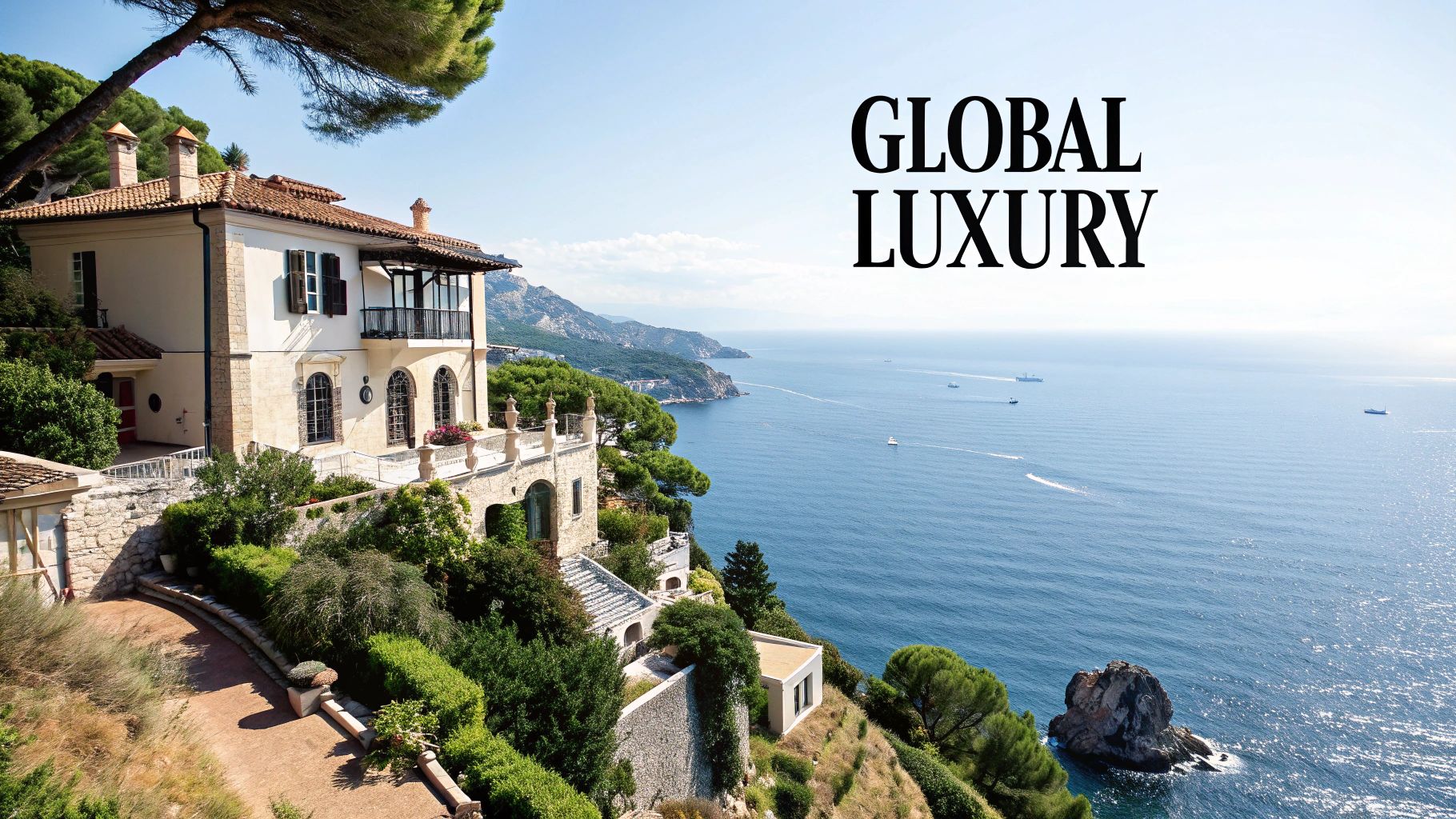 Luxurious Mediterranean villa on a cliff overlooking the sparkling blue sea with boats.