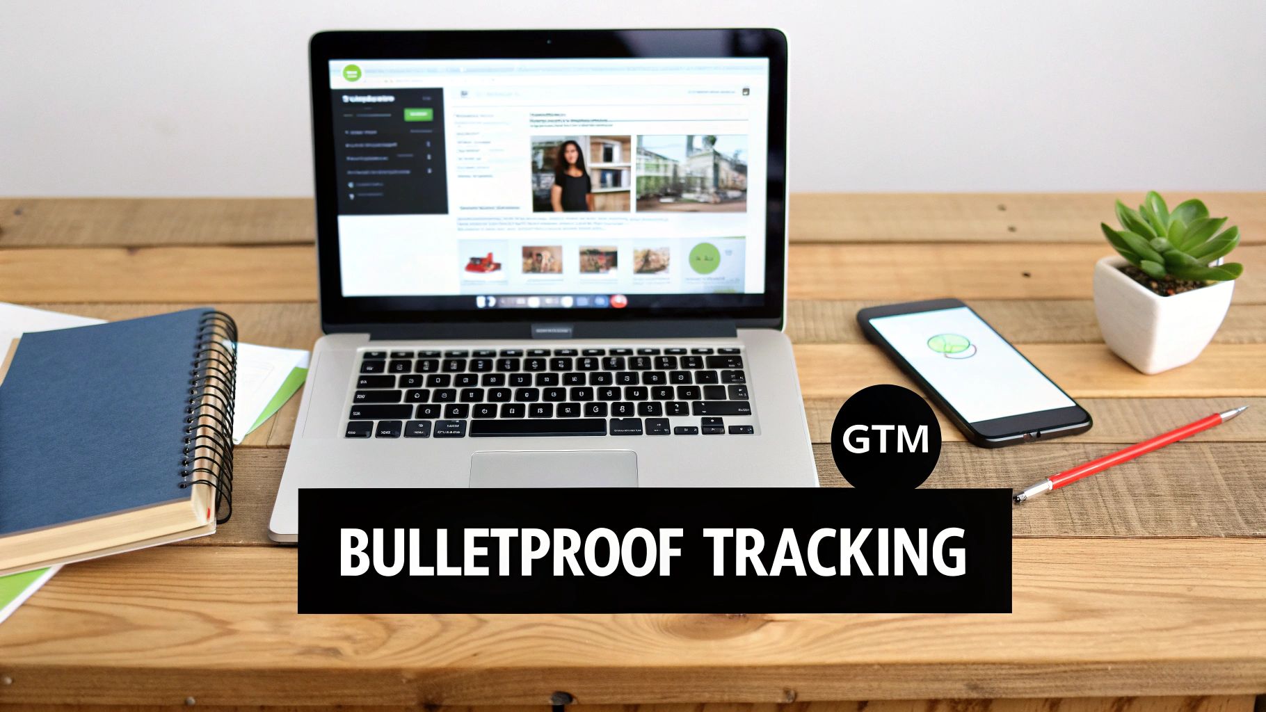 Laptop displaying 'Bulletproof Tracking' and 'GTM' on a wooden desk with a smartphone, notebook, and plant.