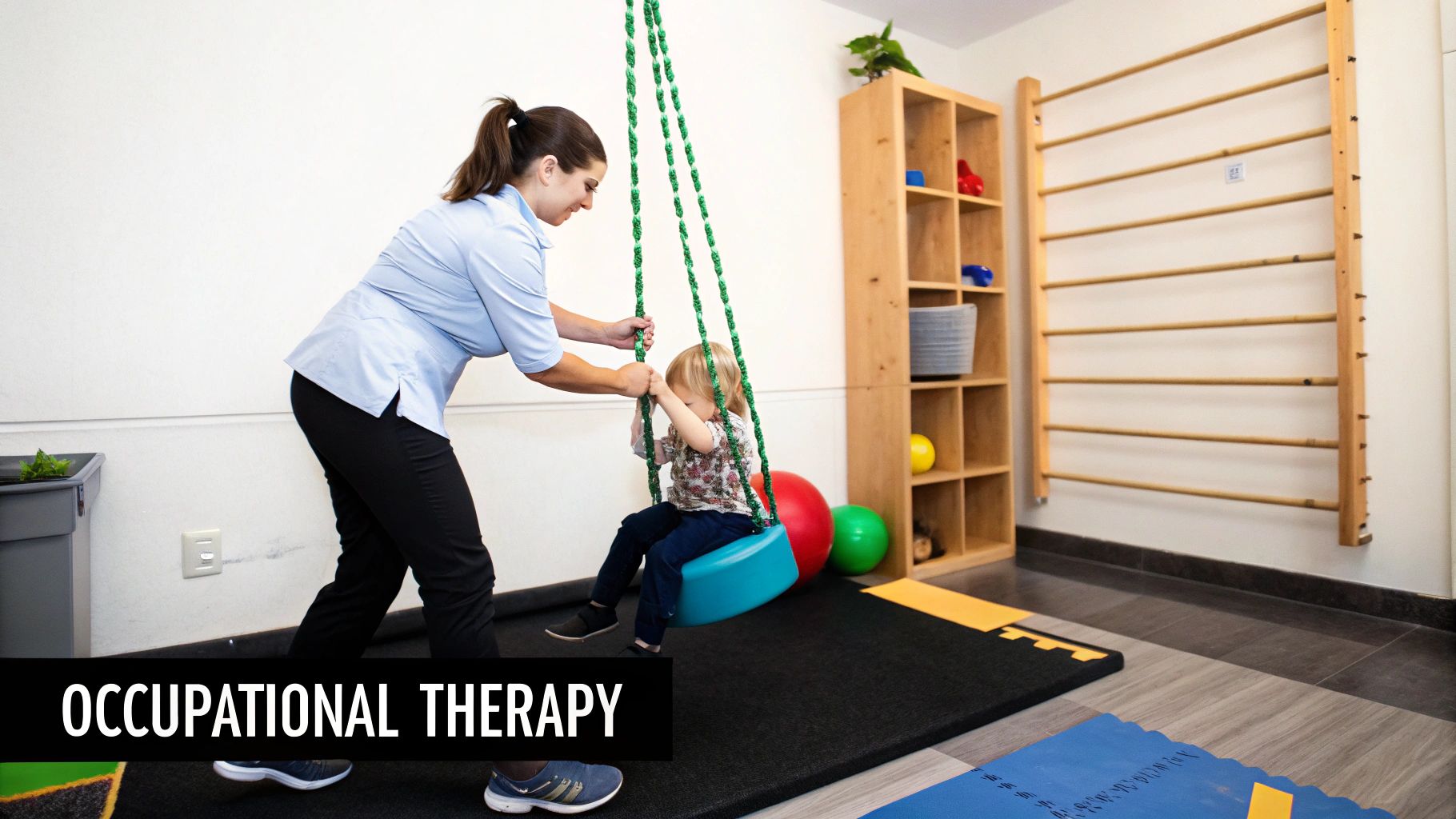 Occupational therapist assisting child on therapy swing in sensory integration treatment room