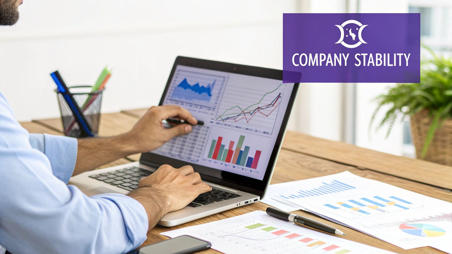 A person at a desk with multiple computer screens displaying charts and data, representing research on high-potential companies.