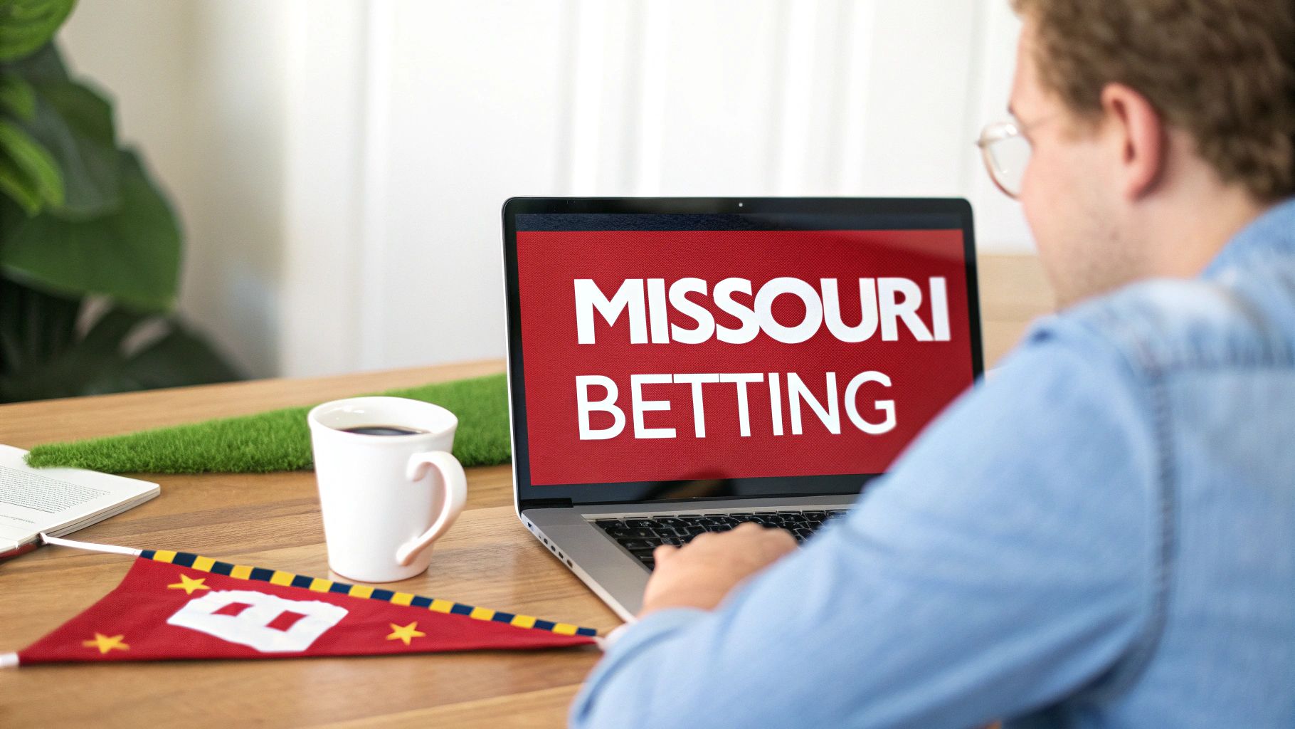 A person views a laptop screen displaying 'MISSOURI BETTING' with a coffee cup and flag on a wooden desk.