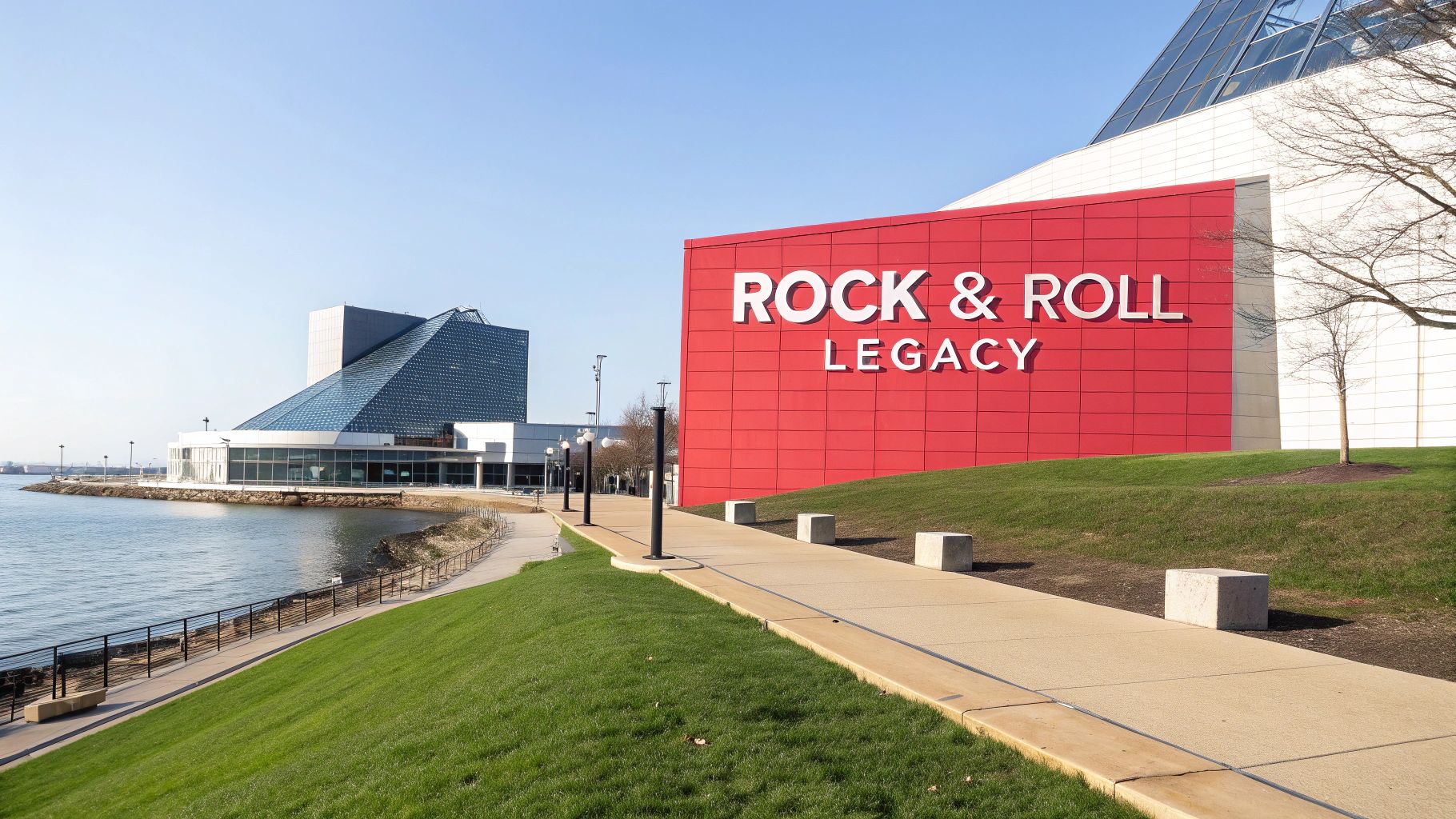 The Rock & Roll Hall of Fame building in Cleveland with a prominent red wall displaying "ROCK & ROLL LEGACY" text by the waterfront.