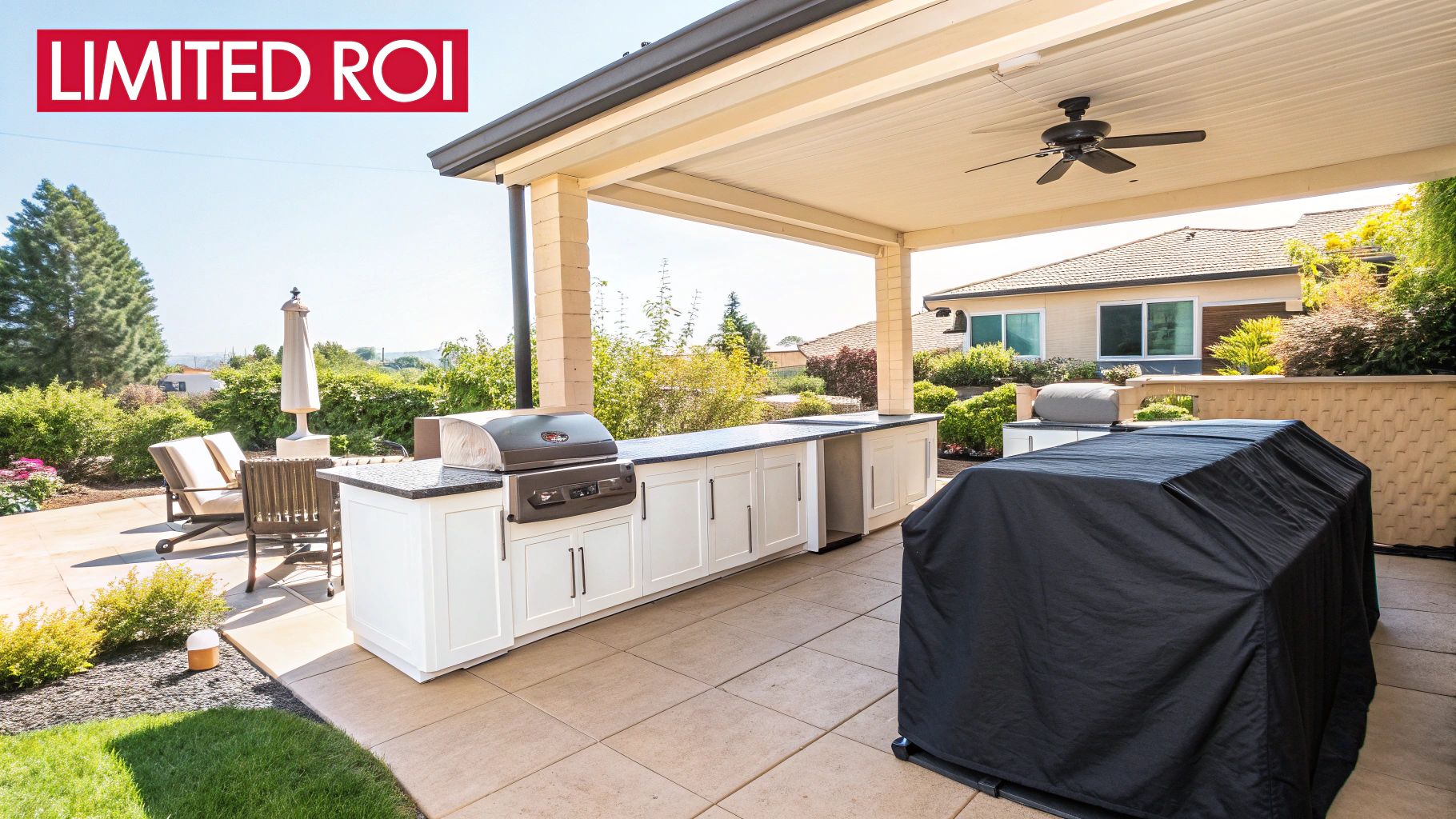 Luxury outdoor kitchen with built-in grill, white cabinets, and covered patio featuring ceiling fan
